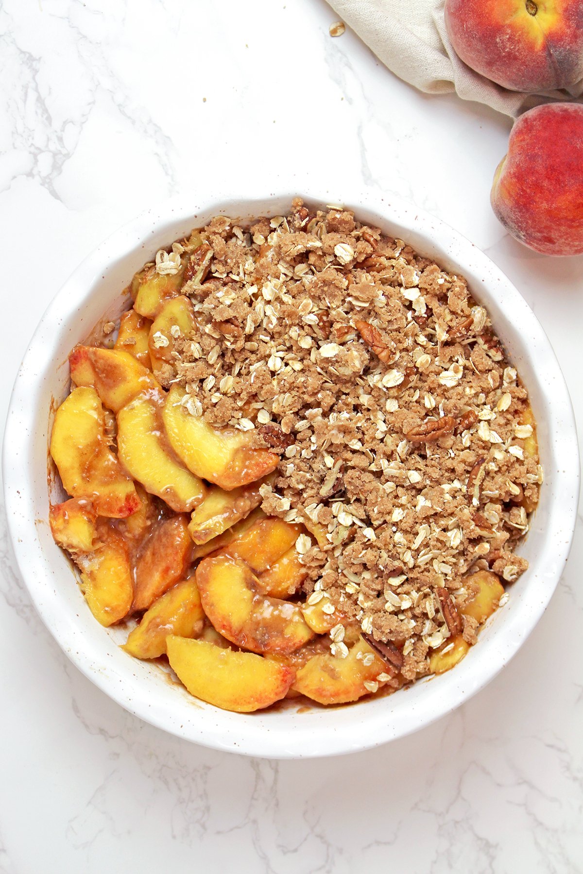 Step 3 - Assembling the peach crips
Fresh peach filling spread in a baking dish and topped with a chilled oat crumble topping.