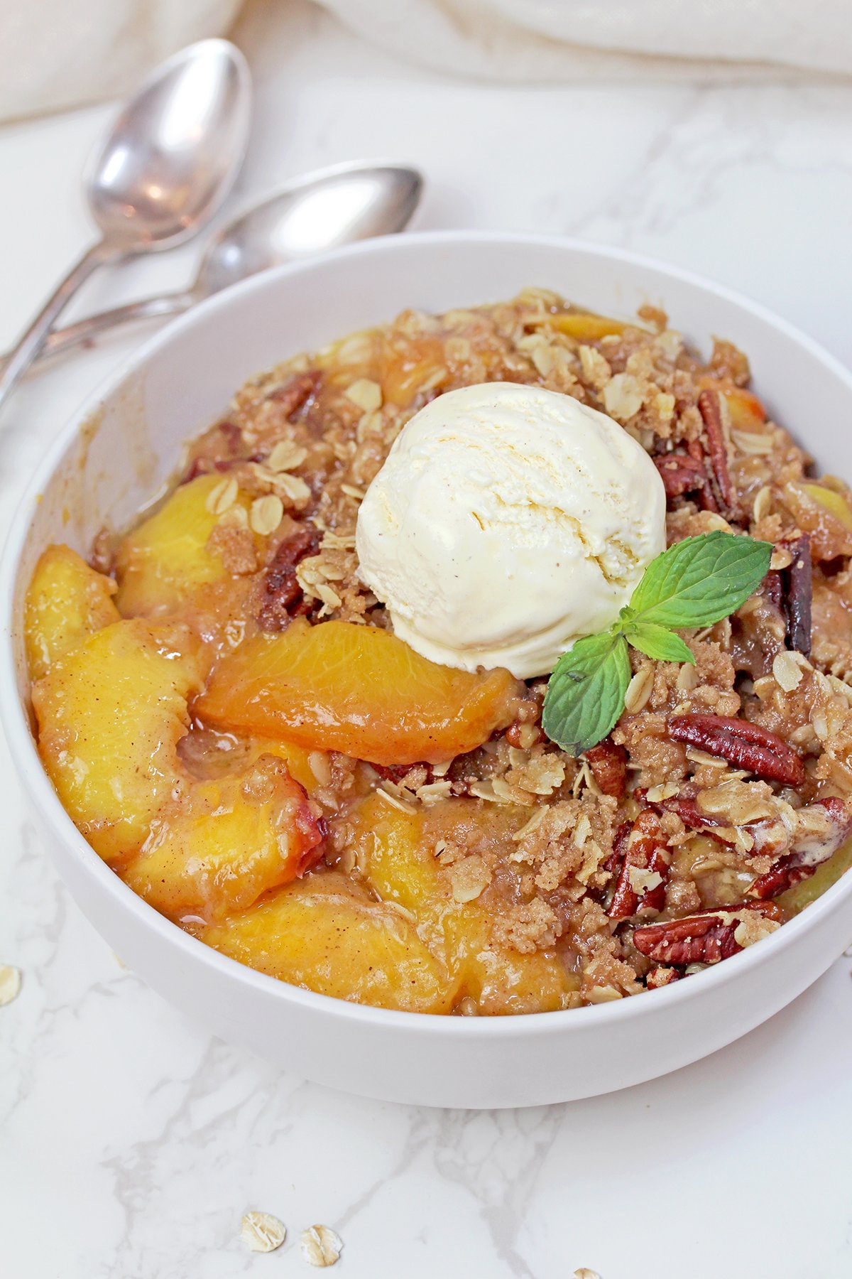 Warm homemade summer dessert served with a scoop of creamy vanilla ice cream.