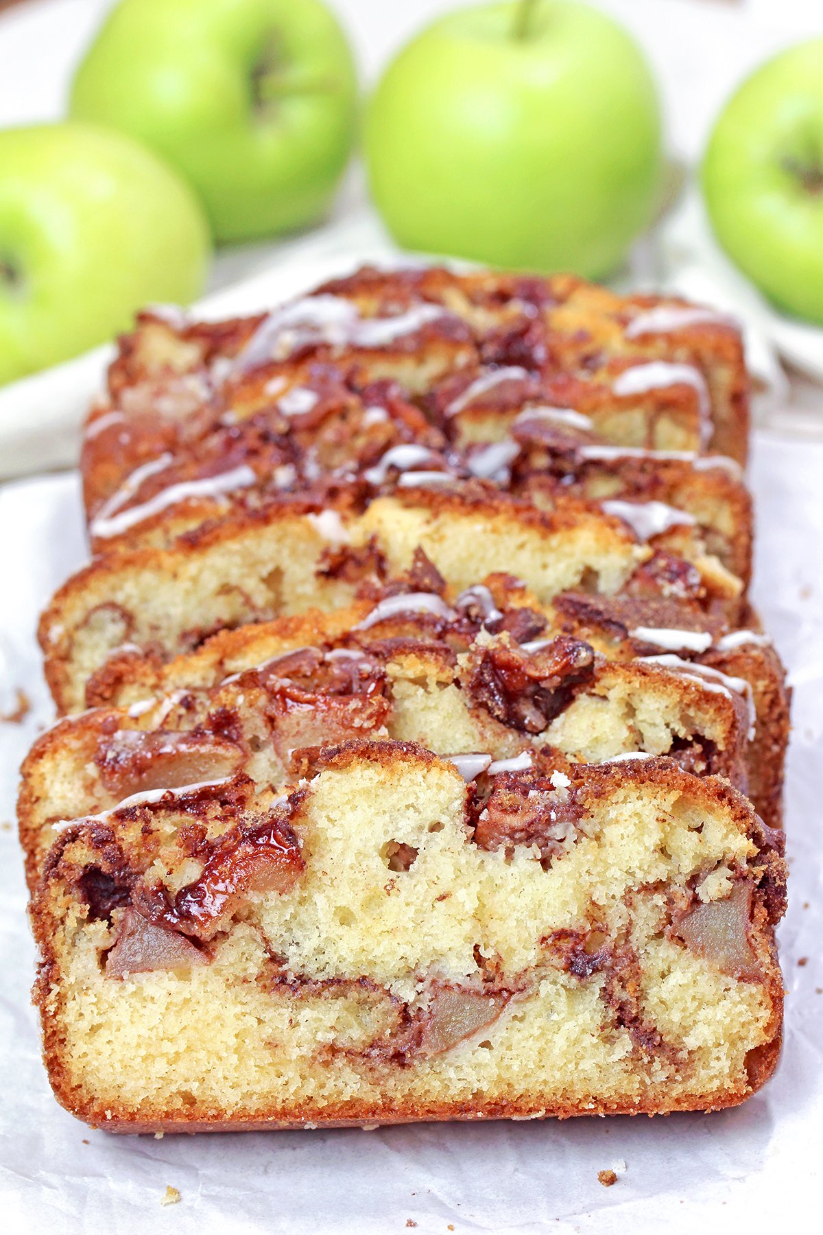 Homemade apple cinnamon bread loaf with apple pieces and cinnamon sugar topping.