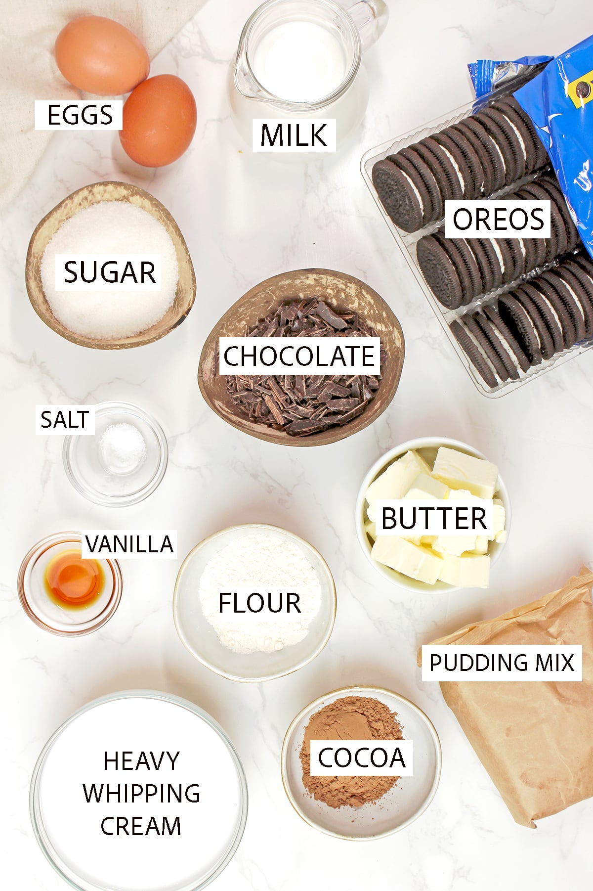 Mississippi Mud Pie ingredients including Oreo cookies, butter, chocolate, cocoa powder, instant chocolate pudding mix, and heavy whipping cream arranged on a countertop.