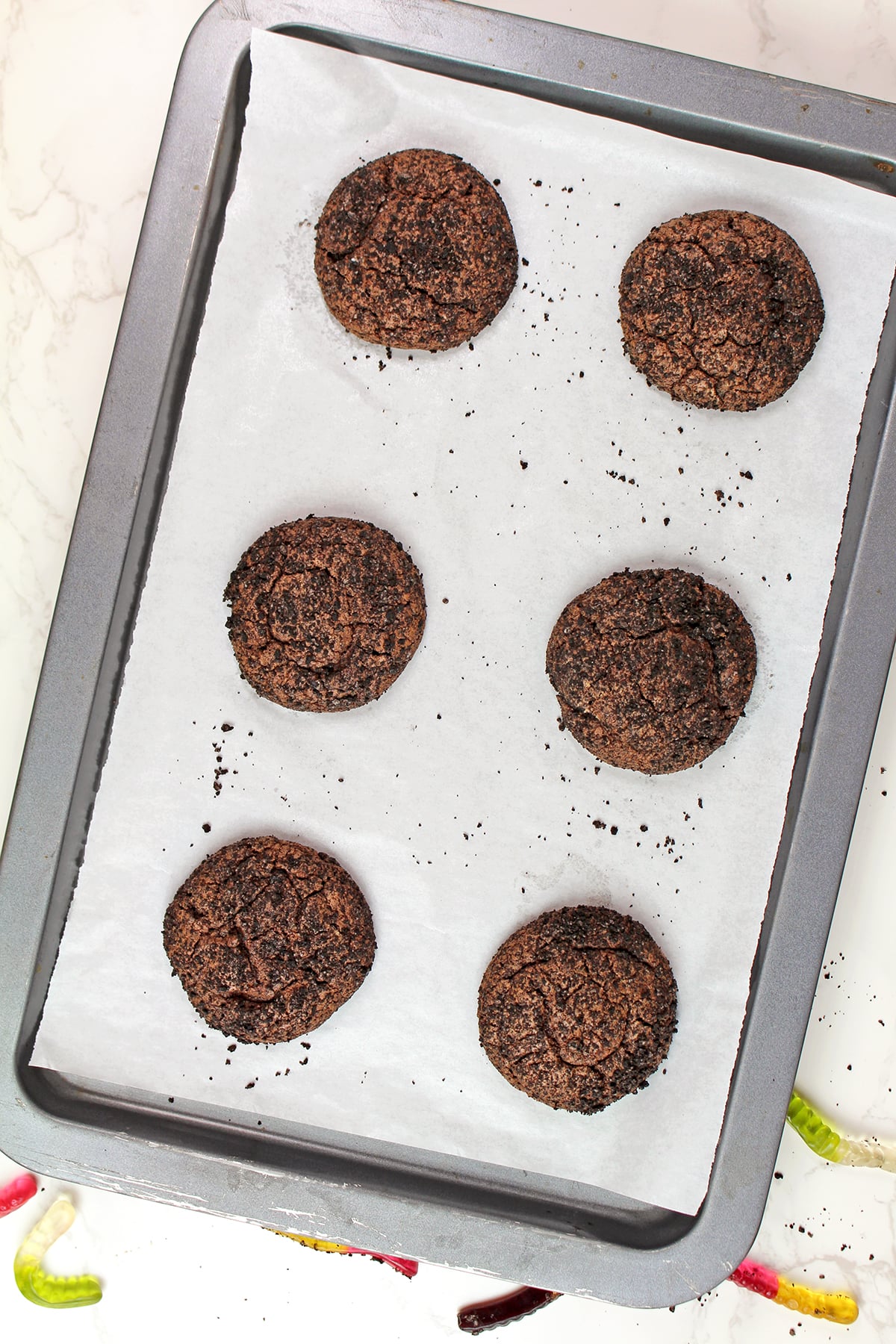 Freshly baked chocolate cookies on a baking sheet.
